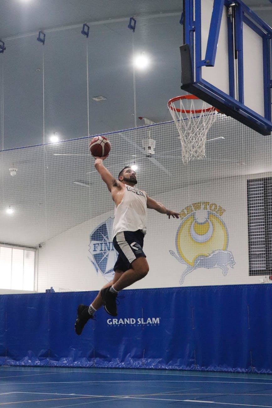 man in white tank top playing basketball