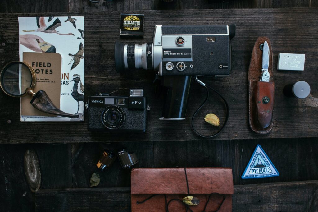 retro cameras near knife and lens near film on desk