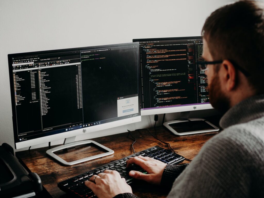 man working on computers coding