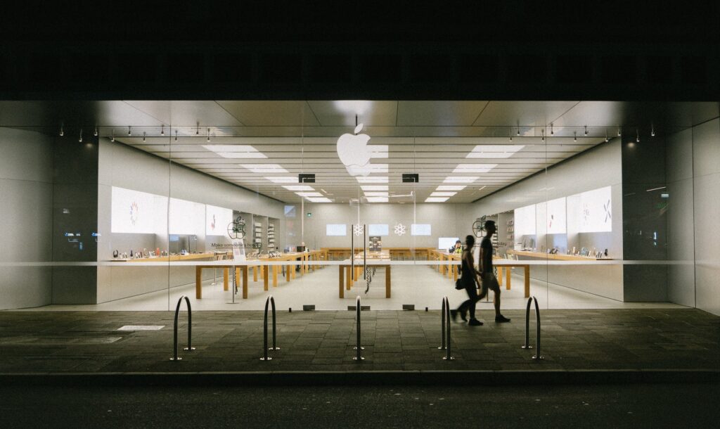 people walking on the sidewalk near a store with glass facade